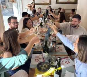 Amigos brindando en una cata de vino en Madrid con copas en alto y mesa compartida